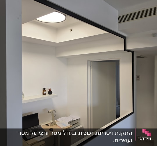 משרד קטן עם חלון זכוכית ושולחן עבודה